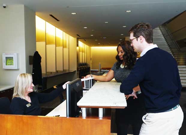 Two attendees at concierge desk receiving help
