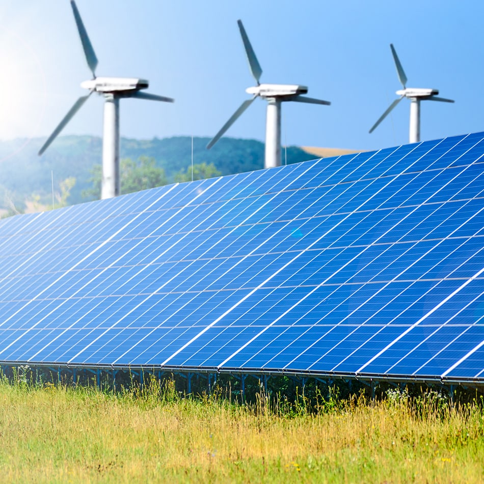 A group of wind turbines producing energy alongside solar panel