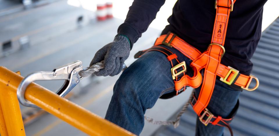 Construction worker using safety harness and safety line on a construction site project