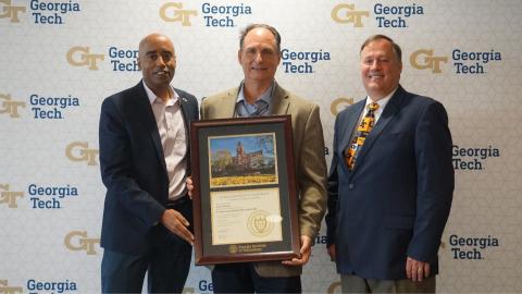 Men holding a framed tech tower picture and certificate, including Georgia Tech Professional Education Interim Executive Director and Associate Dean Steve Ruffin.
