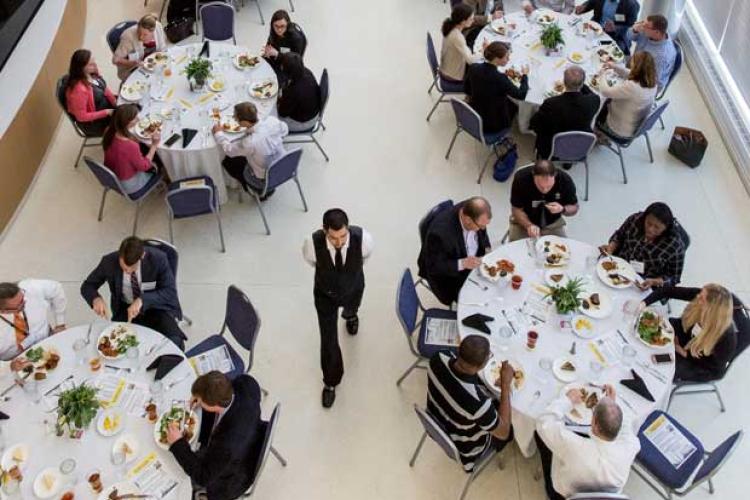 Aerial shot of individuals eating at groups of round tables