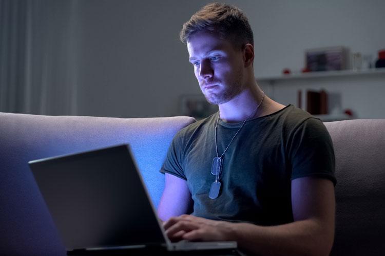 Military professional wearing military tags working and learning on laptop