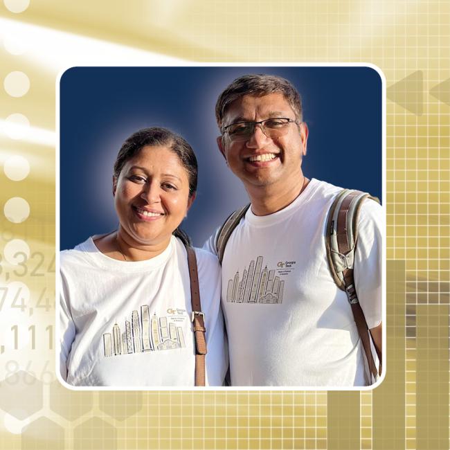Man and woman smiling, stand side-by-side in white t-shirts against a gold background.