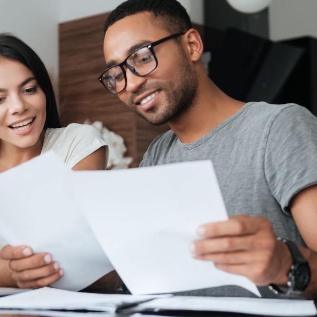 Financial services professionals analyzing their finances with documents and a laptop.