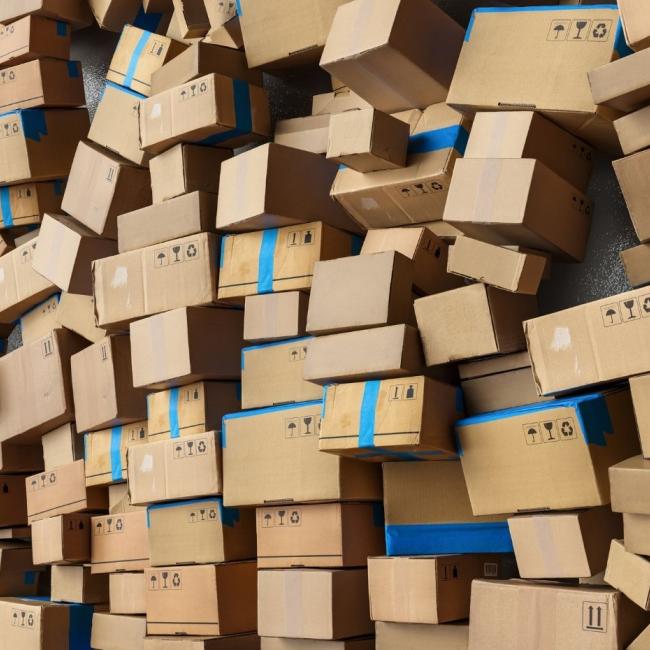 Many stacked cardboard shipping boxes in logistics warehouse before moving to delivery.