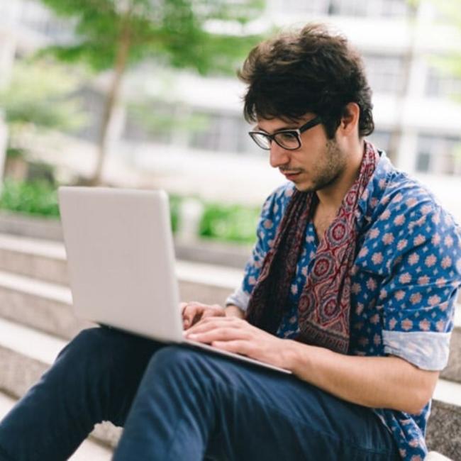 A person sitting on steps using a computer